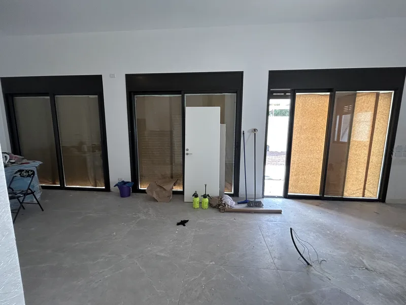 דלתות וחלונות אלומיניום עם פרופילים צבועים בשחור בבית פרטי